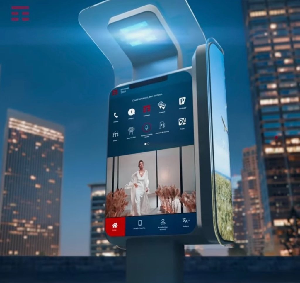 Cabina telefonica digitale TIM circondata dai grattacieli di Milano 