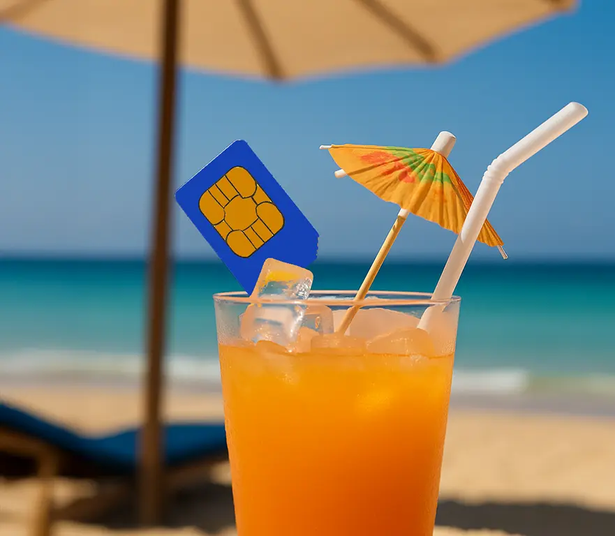 Drink in spiaggia con SIM turistica al posto della fetta di limone, simbolo del silenzio digitale estivo nel settore telco