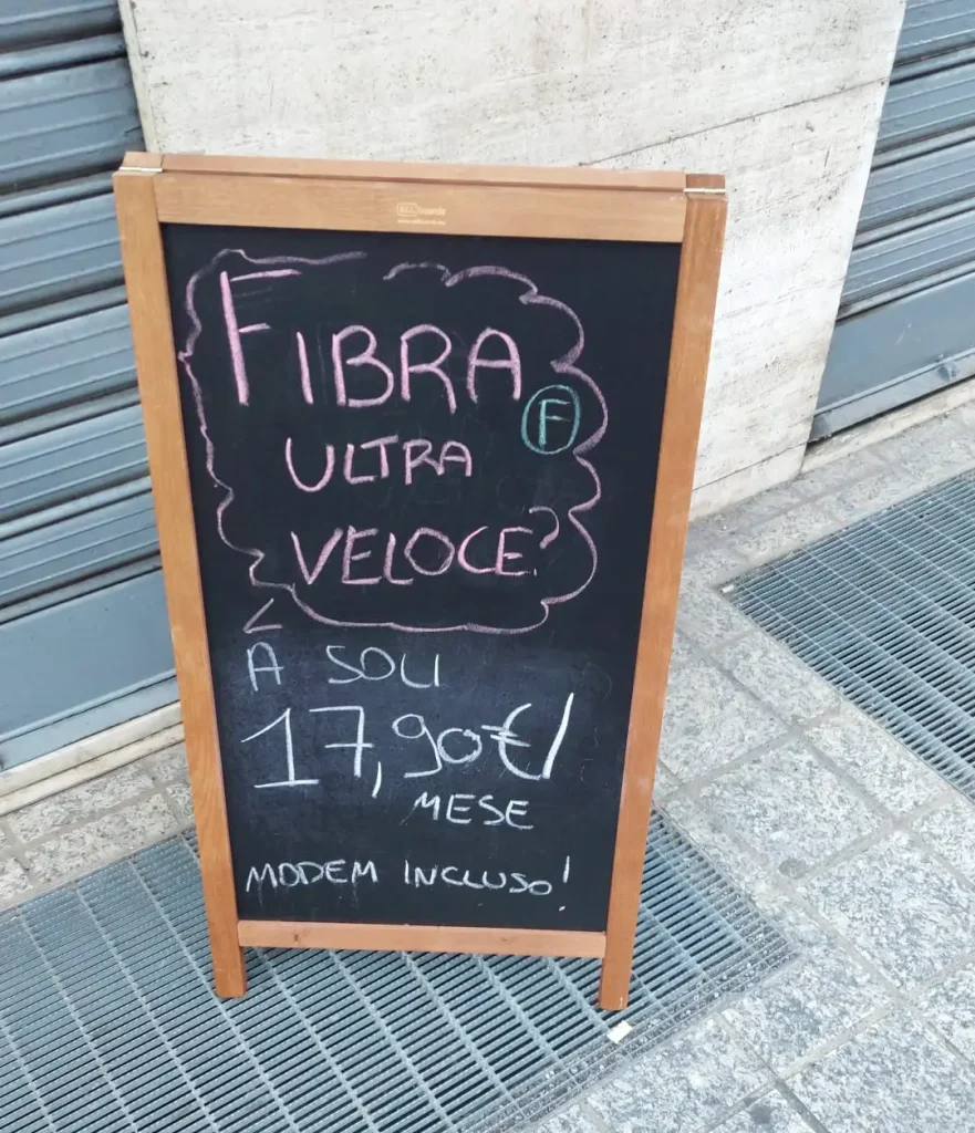 Guerra dei prezzi nella telefonia: Cartello in strada con prezzo fibra ottica stracciato 