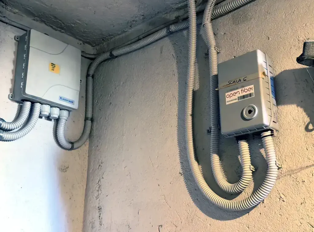 Armadio Flashfiber e terminazione Open Fiber installati nello stesso cavedio condominiale a rappresentare la duplicazione reti fibra ottica